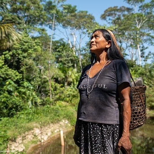 Mujer wampi de pie en medio de la amazonía